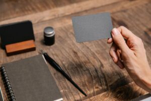 Main tenant une carte grise vierge au-dessus d’un bureau de travail